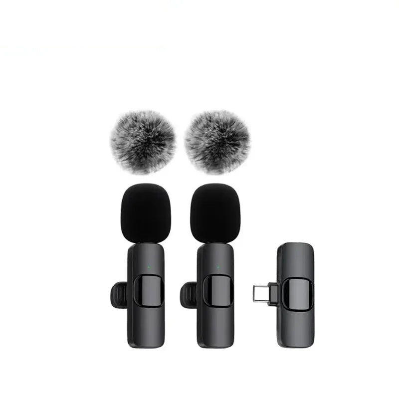 Two wireless lavalier microphones with windscreens beside the receiver on a white background