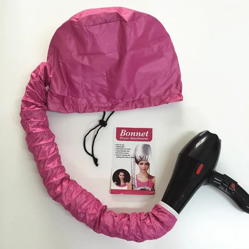 Pink bonnet dryer attachment coiled beside its packaging and a hair dryer