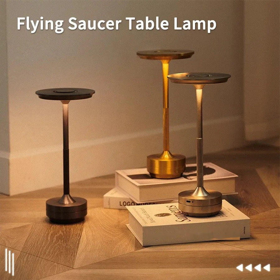 Wireless touch candle table lamp resting on a book on a wooden table