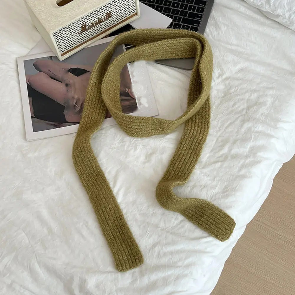 Olive cashmere scarf looped, flat lay on white bedding