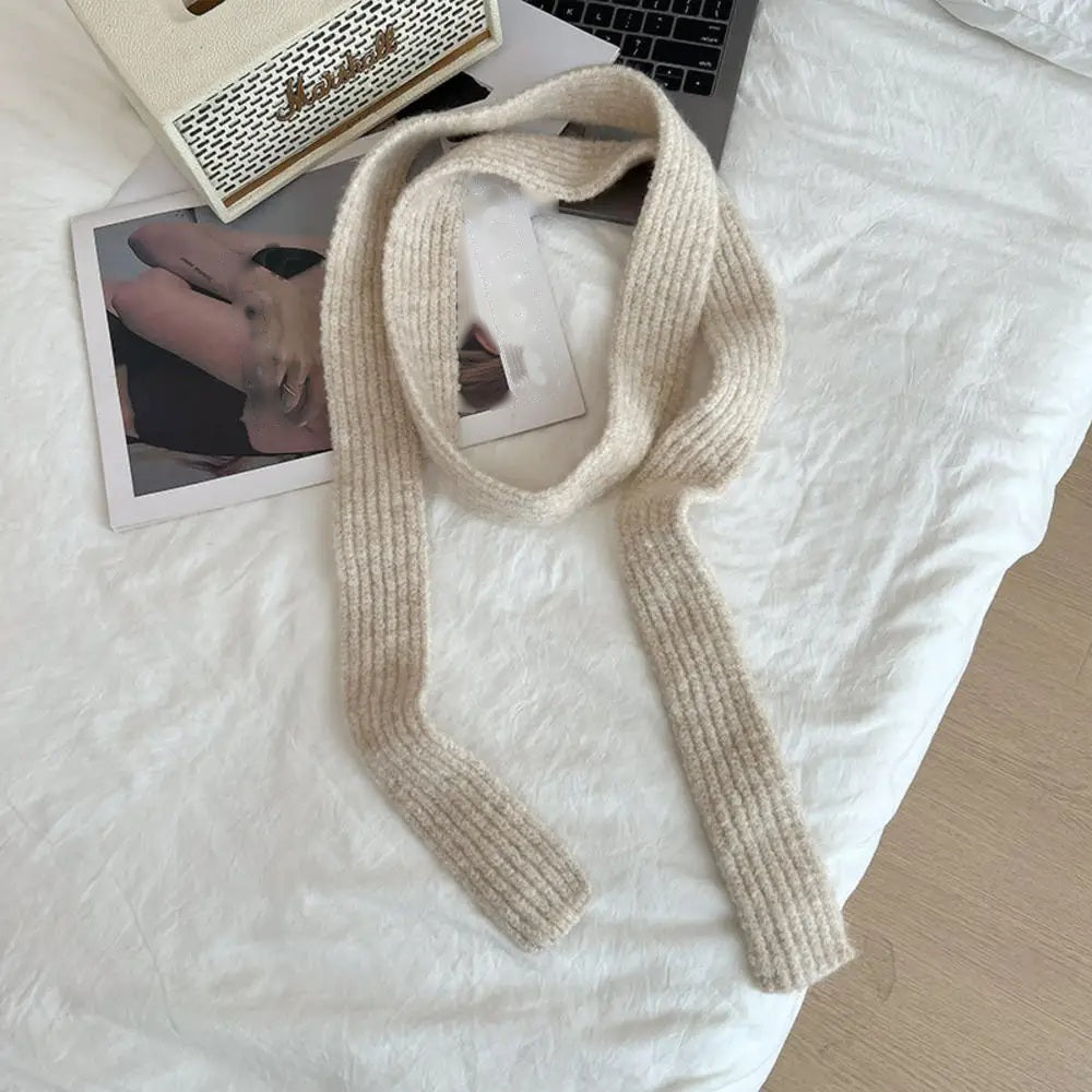 Ivory cashmere scarf looped, flat lay on white bedding