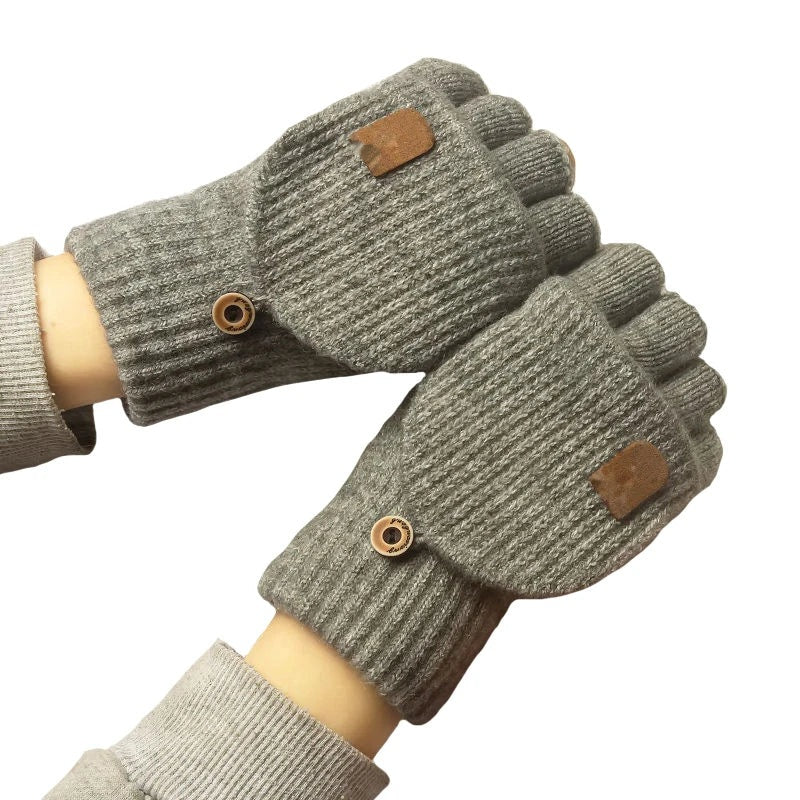Grey knitted fingerless gloves with fold-over mitten flaps worn on hands