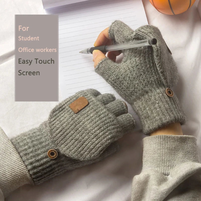 Grey knitted fingerless gloves worn while writing with a pen