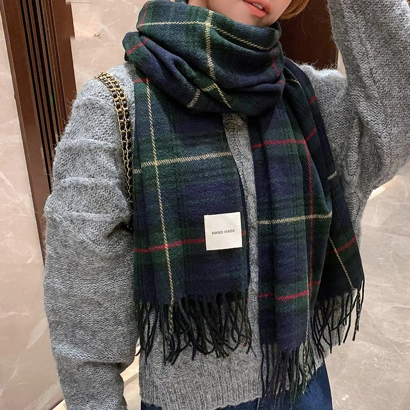Woman wearing the green plaid winter scarf with a grey jumper