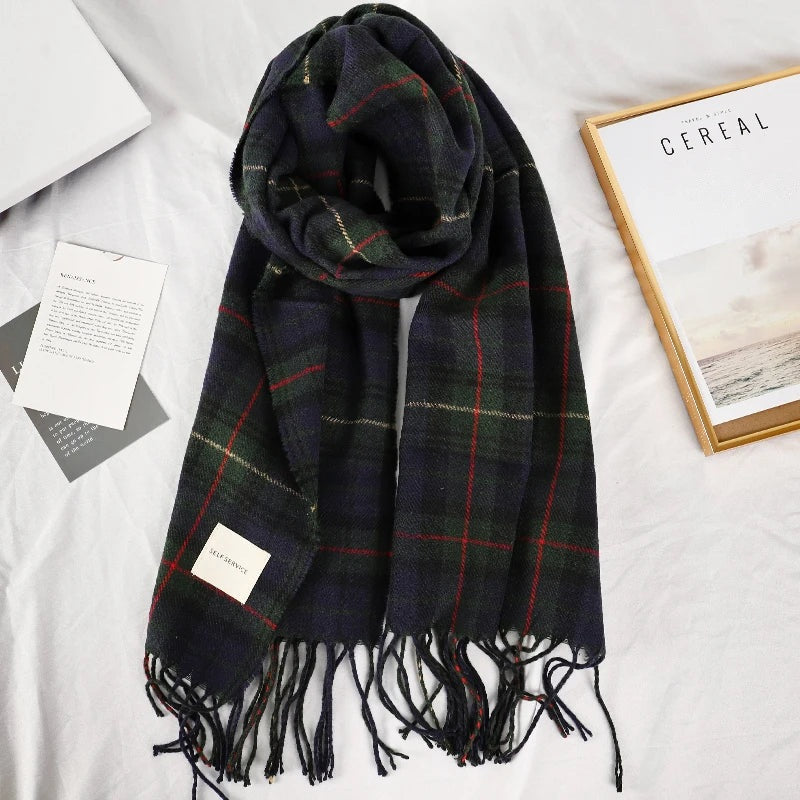 Navy and green plaid scarf laid flat with fringed ends