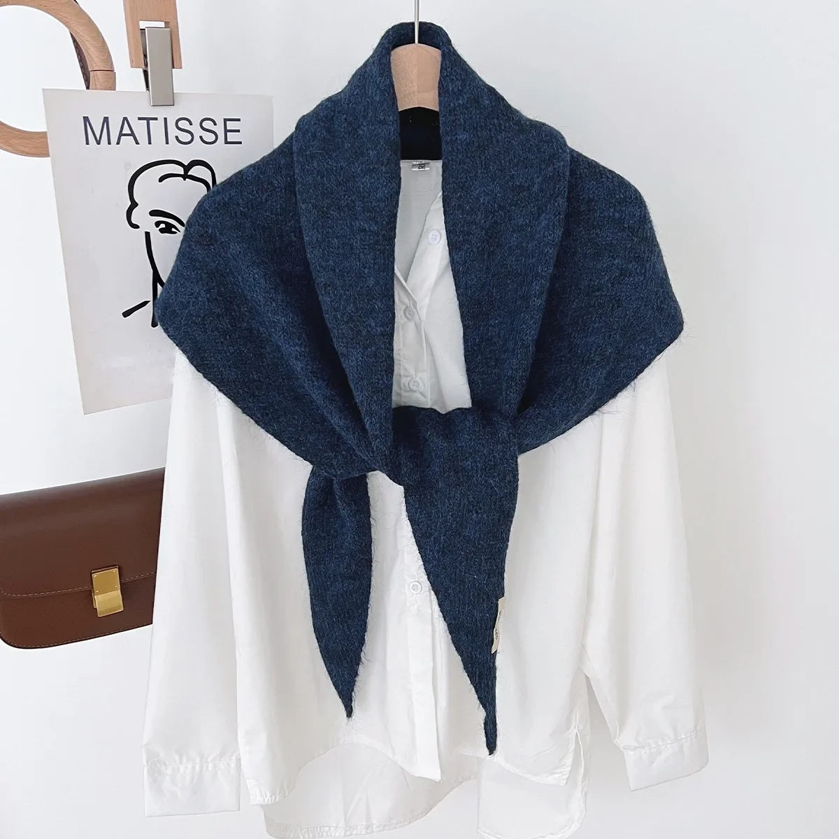 Navy knit triangle wool scarf displayed on a hanger