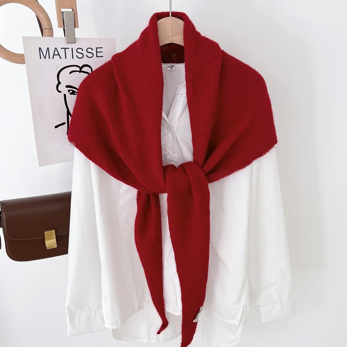 Red knit triangle wool scarf displayed on a hanger