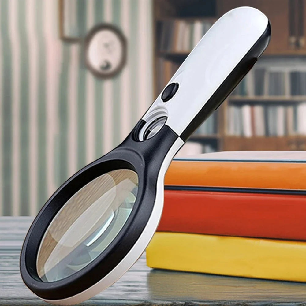 Handheld magnifying glass resting on a stack of books in a study