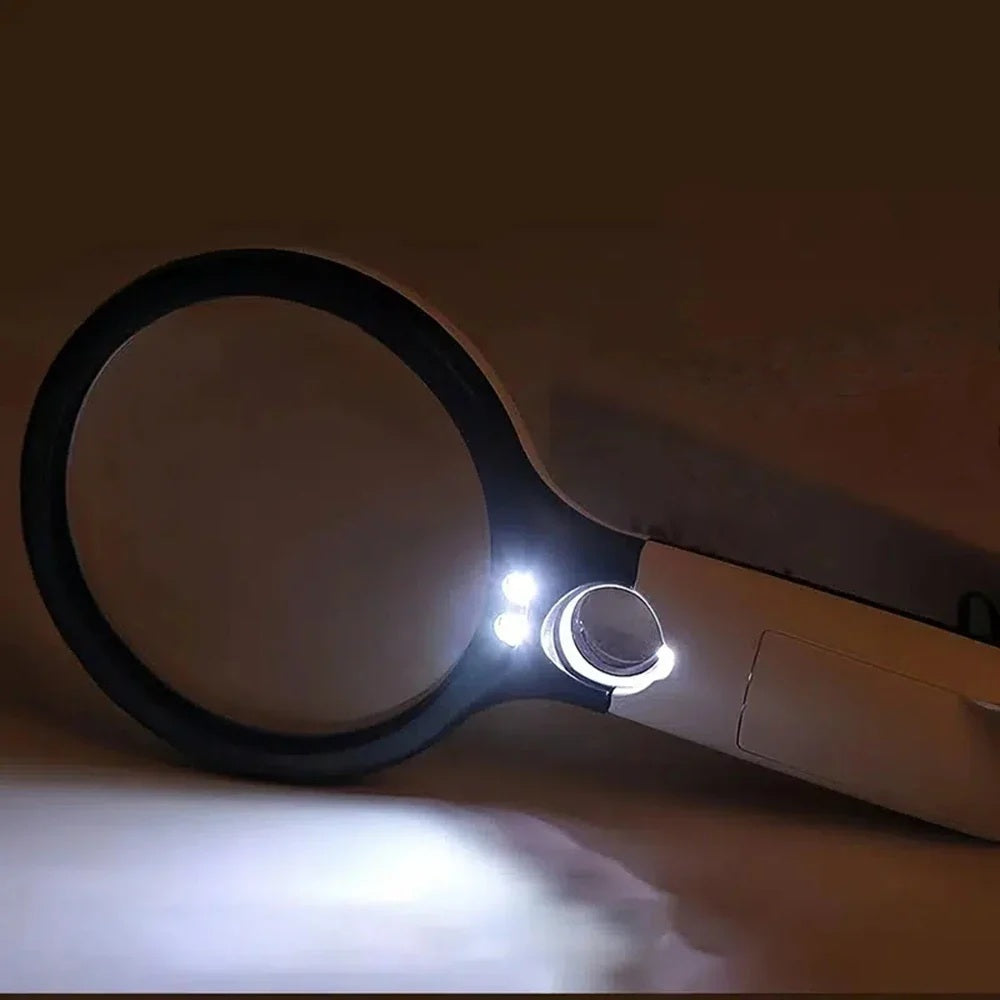 Magnifying glass with its LED light switched on in a dimly lit room