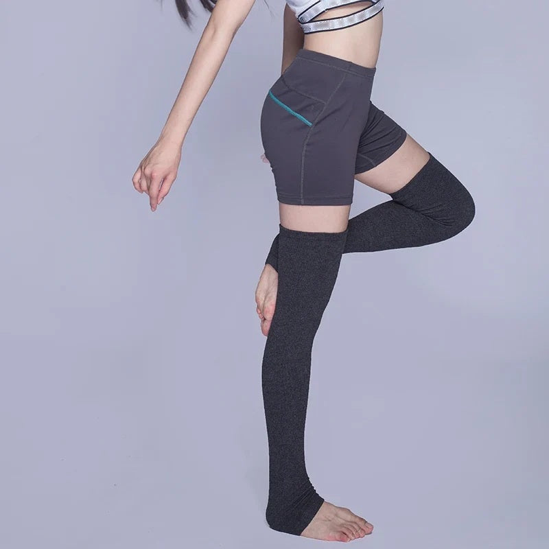 Model wearing charcoal knitted thigh-high leg warmers, side pose