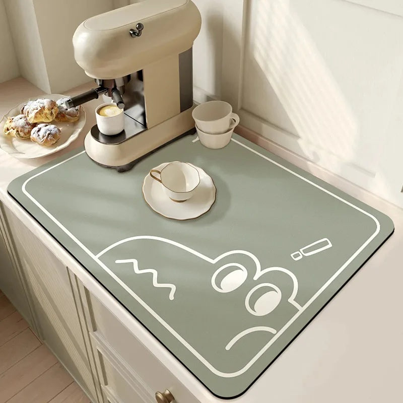 Sage green absorbent kitchen drying mat with a cup and saucer on a counter