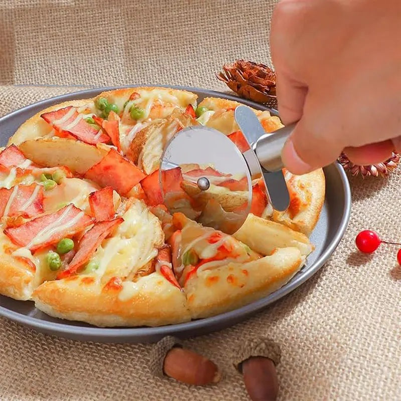 Stainless steel pizza cutter wheel slicing a pizza on a metal tray