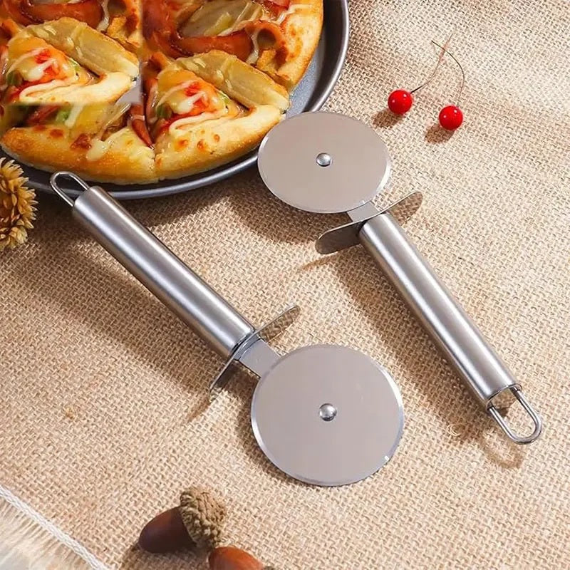 Two stainless steel pizza cutter wheels beside a pizza on a linen surface