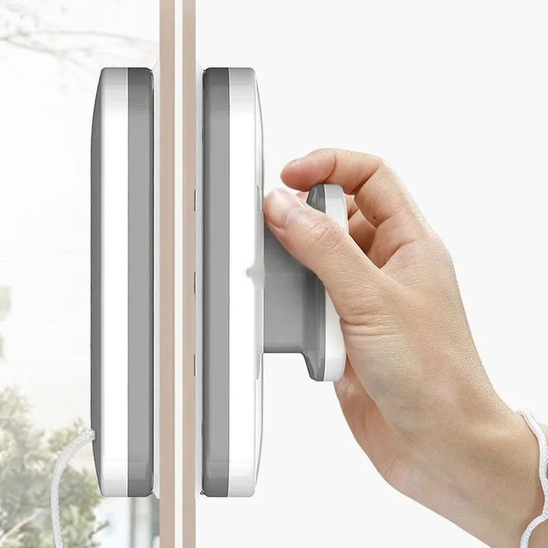 Hand pressing the magnetic window cleaner against the glass