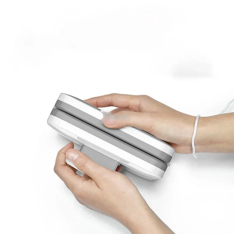 Hands separating the two halves of the magnetic window cleaner