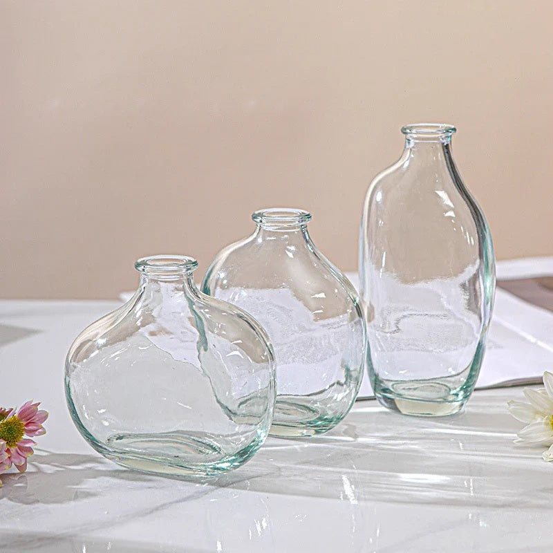 Three clear glass bud vases grouped on a white table