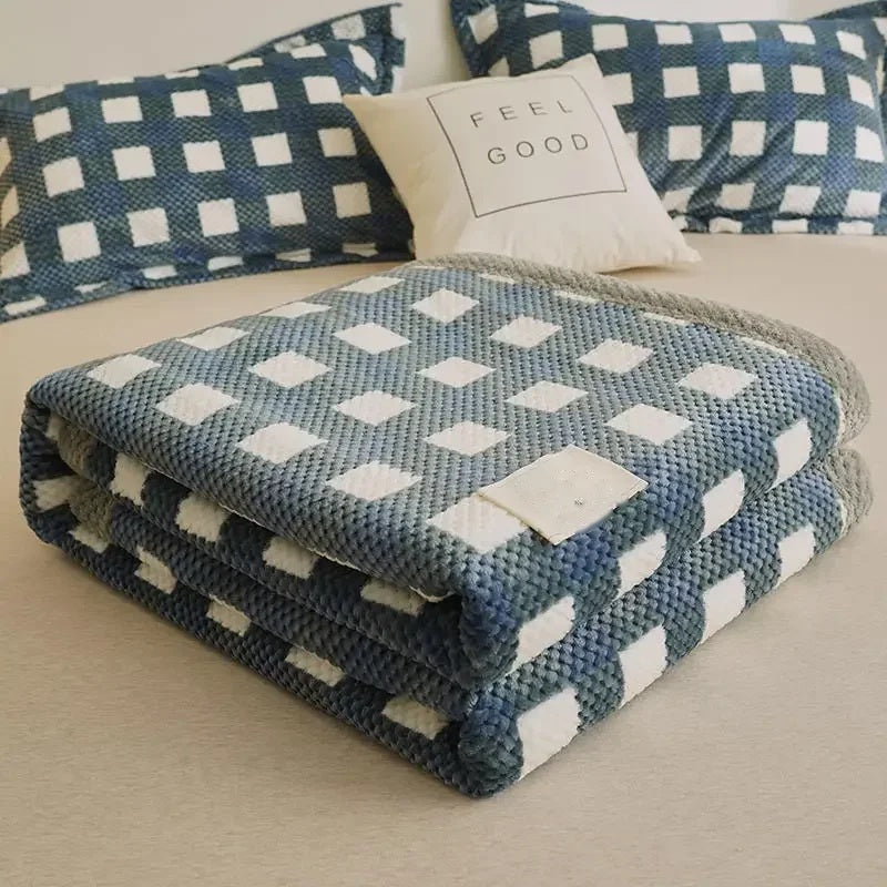 Folded chenille knit throw blanket on a bed with pillows