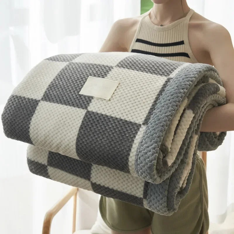 Rolled chenille knit throw blanket held in the arms, grey check