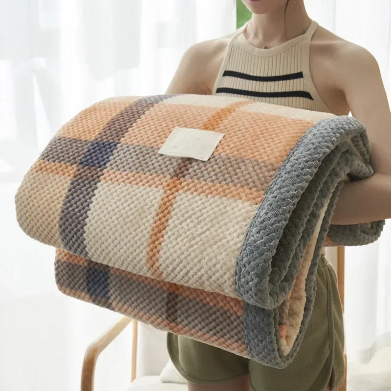 Rolled chenille knit throw blanket held in the arms, orange check