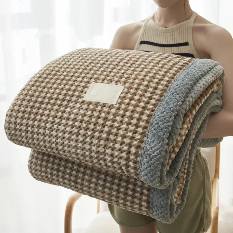 Rolled chenille knit throw blanket held in the arms, brown waffle texture