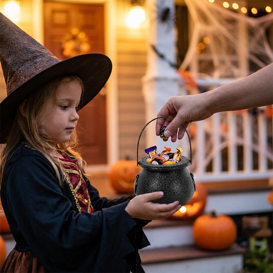 Child holding a witch cauldron treat bucket for sweets