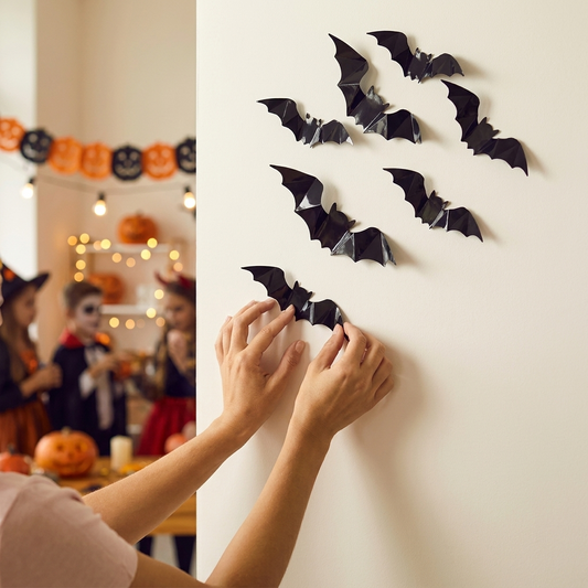 Applying 3D black bat wall stickers to a wall